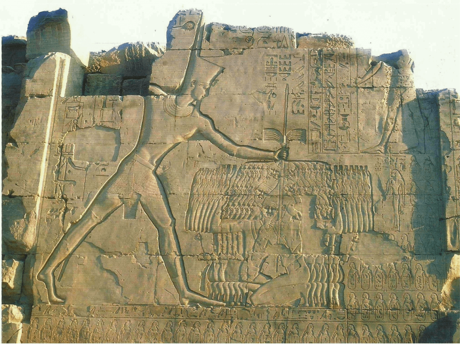 Relevo do sétimo portal do templo de Amon, em Karnak, Egito. Representa o rei Tutmósis III (1479-1425 a.C.) golpeando prisioneiros asiáticos com os braços levantados, suplicando por misericórdia.